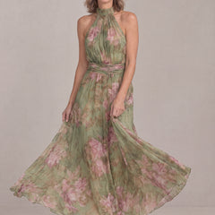 Smiling woman twirling in the Liora floral halter maxi dress, chiffon skirt swirling